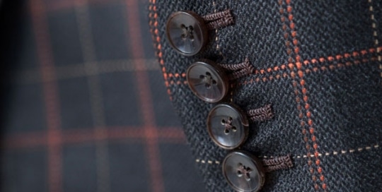 Horn buttons and handmade buttonholes of a silk suit