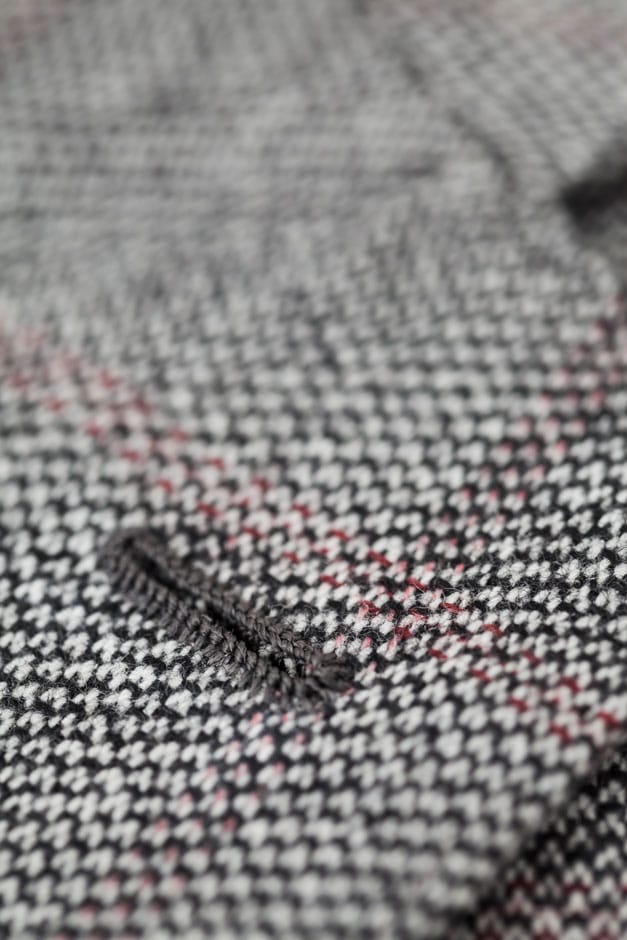 Detailaufnahme eines handumsäumten Reversknopflochs an einem Sakko aus edelstem Kaschmir von Egon Brandstetter Maßschneider Berlin