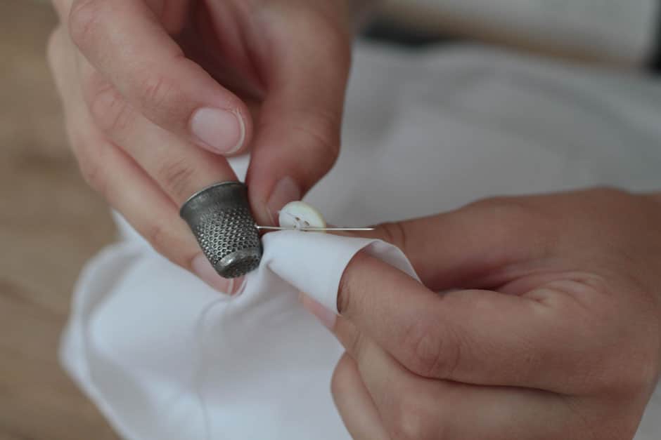 Mother-of-pearl button of a bespoke dress shirt attached by hand